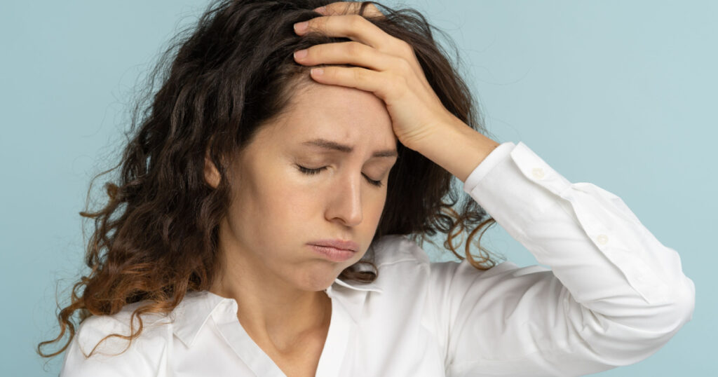 Studio portrait of tired frustrated business woman or office worker sighing and wiping sweat of forehead, has emotional burnout, exhausted by long work during hot weather in the office, isolated.
