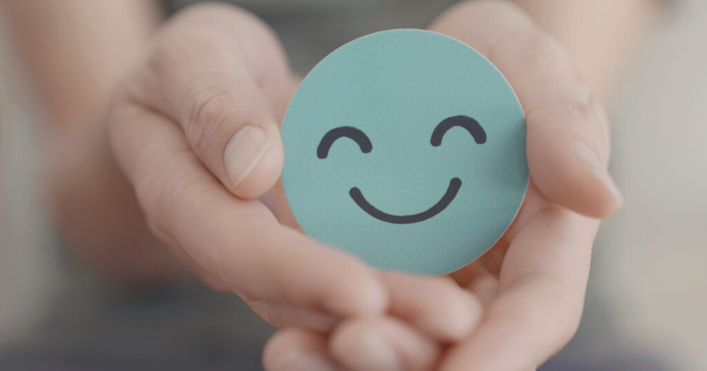 Hands holding green happy smile face, good feedback rating and positive customer review,experience, satisfaction survey,mental health assessment,child feeling good,world mental health day, Compliment