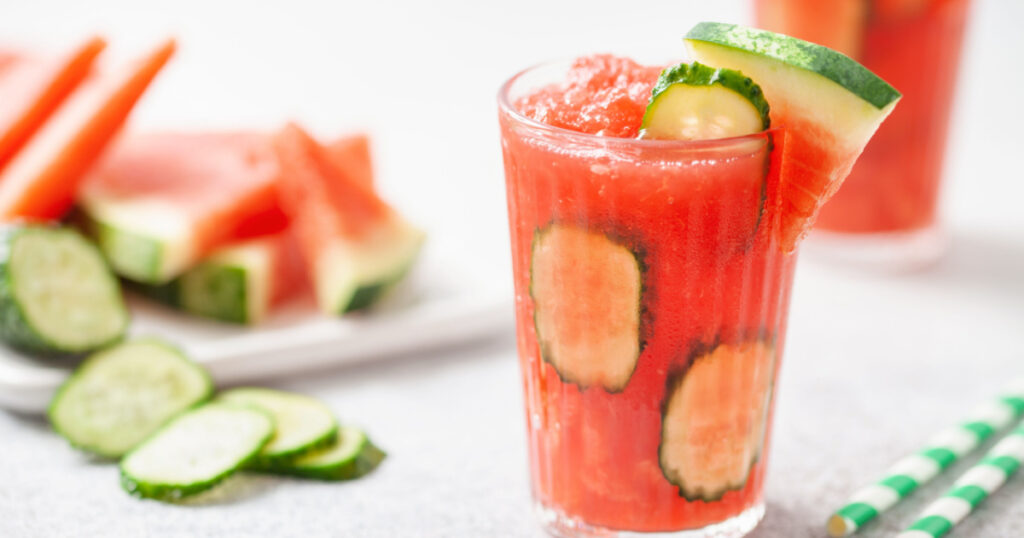 Refreshing cold summer drink watermelon slushie with cucumber slices in glass