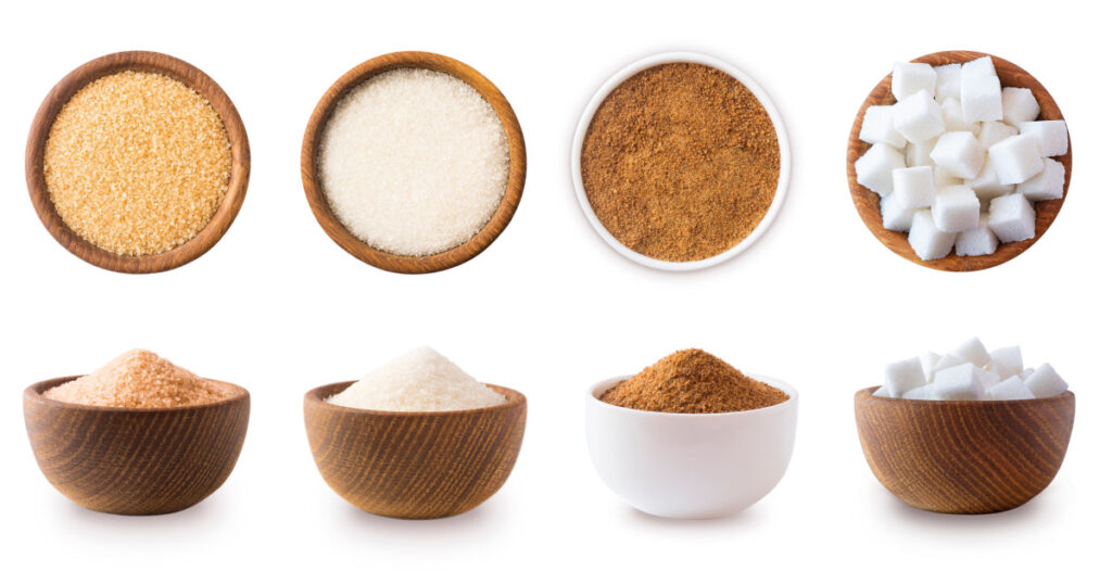 Heap of cane sugar, white and coconut sugar isolated on white Top view. Brown and white sugar isolation in different angles. Natural sugar on wooden bowl isolated on white. Selective focus.