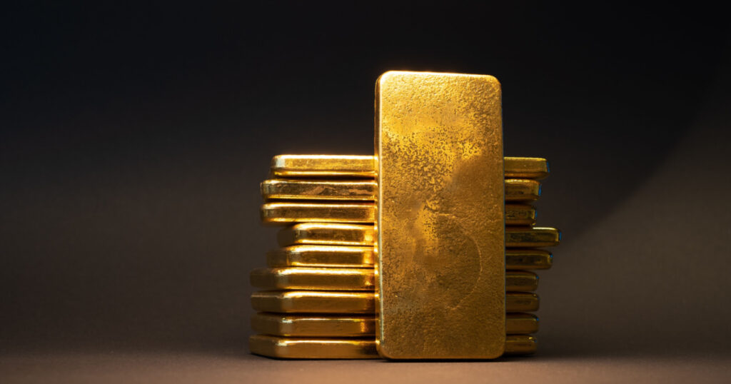 Gold bullion bar on dark background. Large cast investment gold ingot. Swiss gold. Business and finance.
