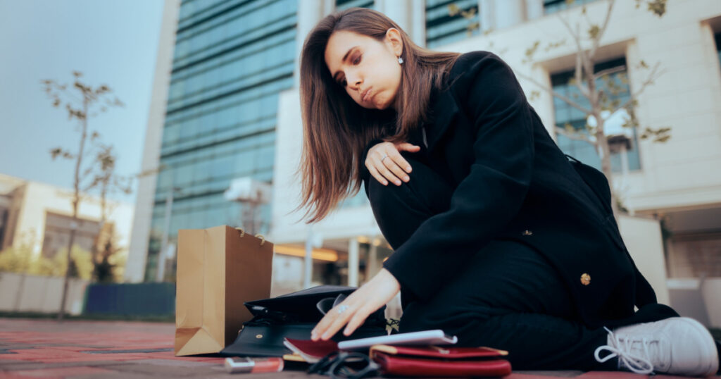 Stressed Woman Dropping Her Bag and Belongings on the Sidewalk. Scatterbrained clumsy girl feeling dizzy and overwhelmed looking for her stuff