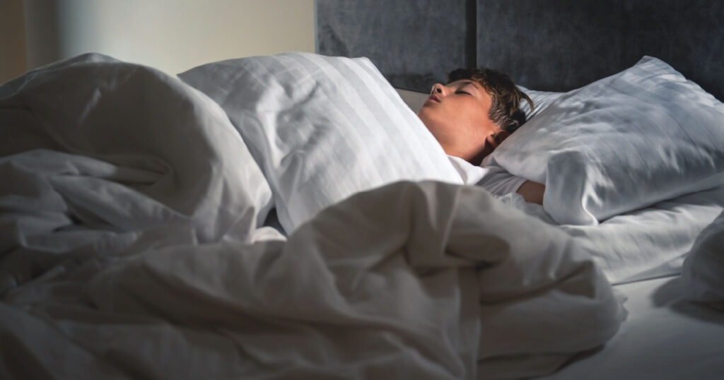 A boy sleeps in his bed.A real scene of sleep and rest