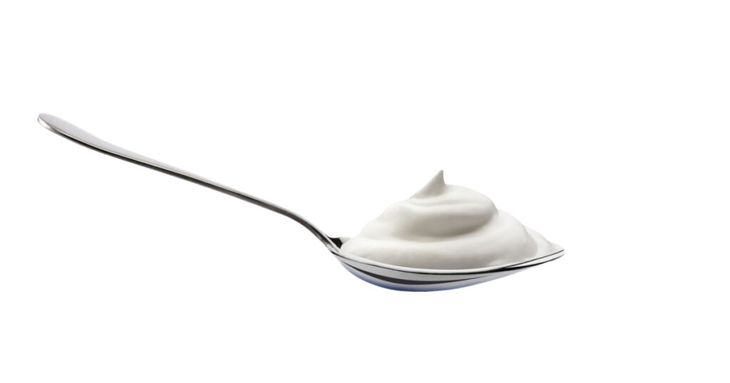 Yogurt spoon with creamy texture isolated