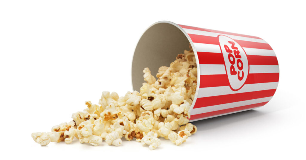 Popcorn in striped bucket on white background