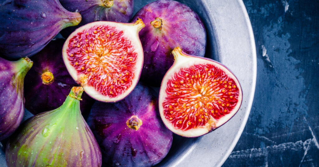 Fresh ripe figs in a bowl closeup on a dark background