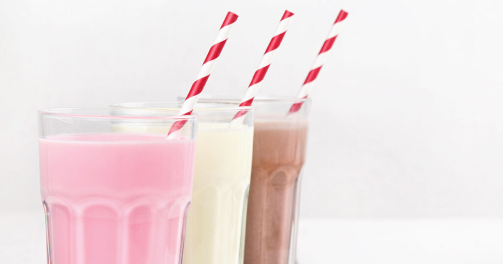 Milkshakes with chocolate, strawberry, banana flavor on a white wooden background
