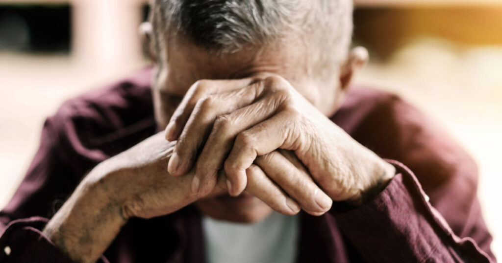 senior man covering his face with his hands.vintage tone
