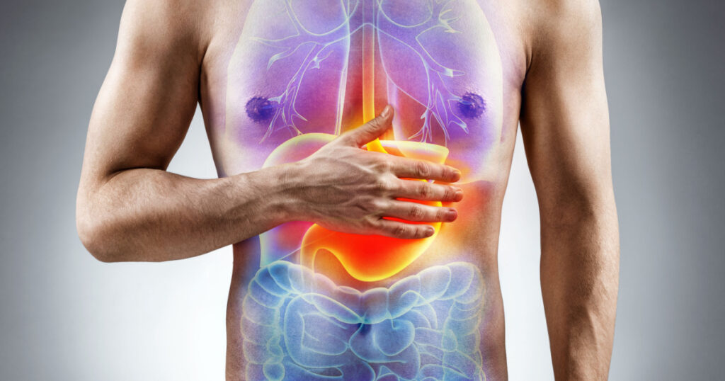 Digestion issue. Man holding his hand in area stomach. Medical concept.