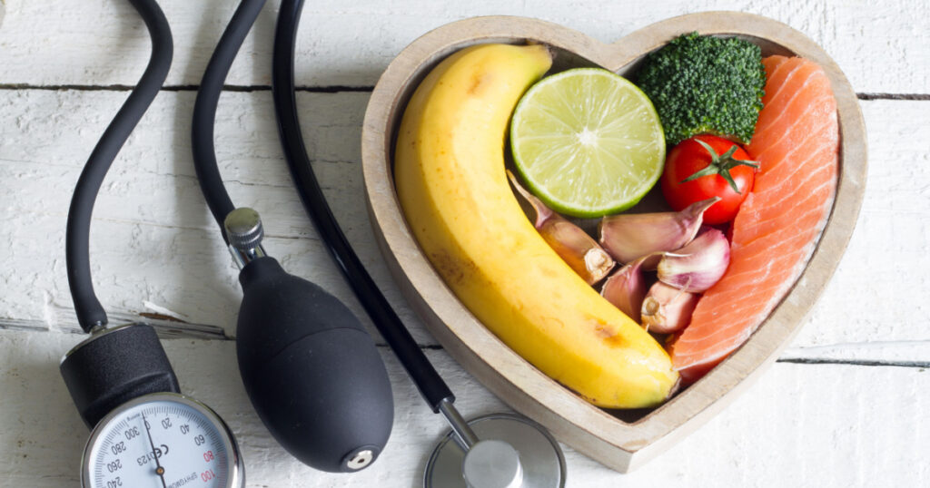 Food and healthy heart diet concept with blood preasure guage on white planks