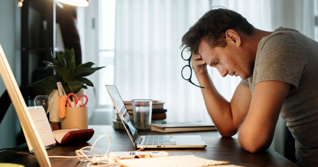 Man stressed while working on laptop