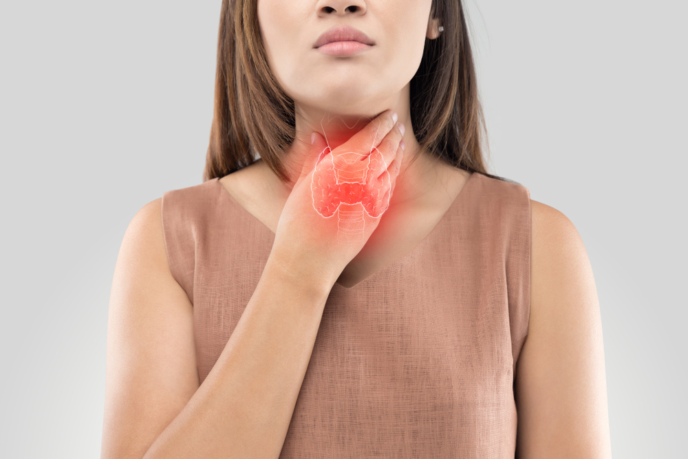 The photo of thyroid is on the human body, Women thyroid gland control. Sore throat of a people against gray background