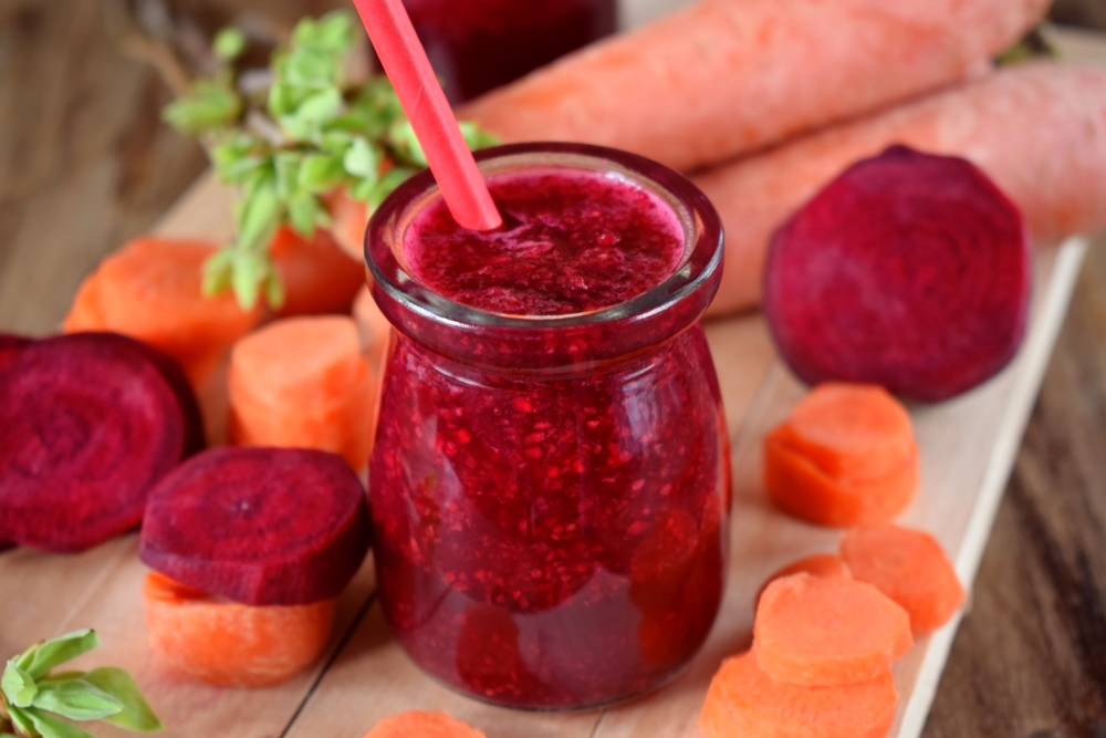 Red smoothie made of carrot and beet in a glass jar