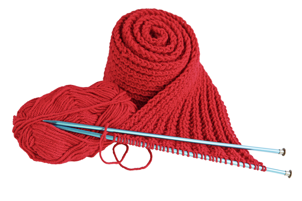 Red yarn and needles making scarf isolated on white