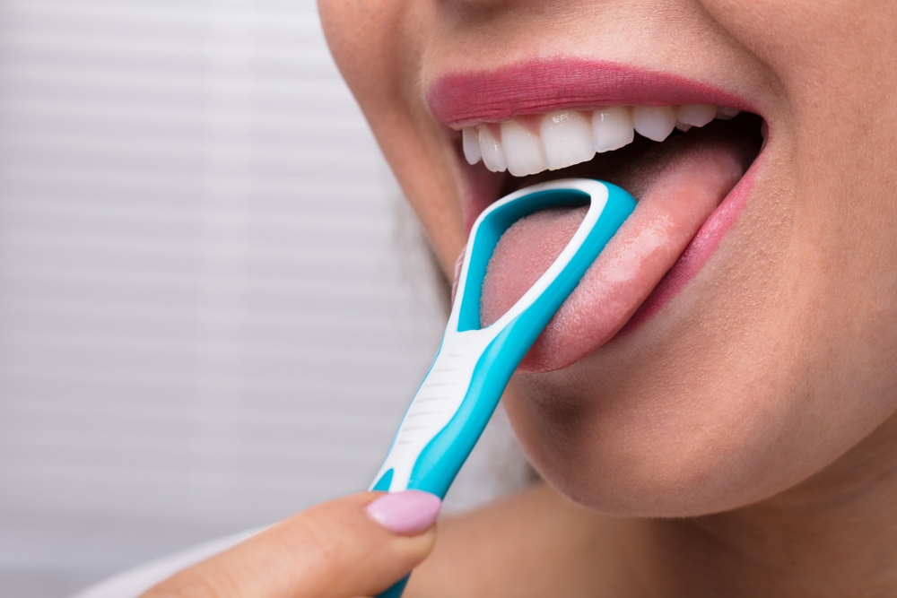 Close-up Of A Woman Cleaning Her Tongue With Cleaner