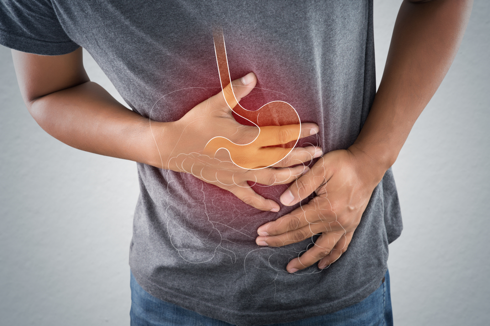 Acid reflux or Heartburn, The photo of stomach and internal organs is on the men's body against gray background, Stomach ache, Bad health, Male anatomy concept.