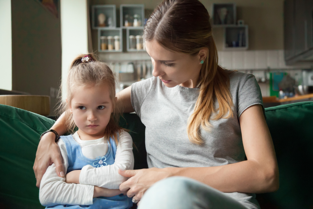 Loving mother consoling or trying make peace with insulted upset stubborn kid daughter avoiding talk, sad sulky resentful girl pouting ignoring caring mom embracing showing support to offended child
