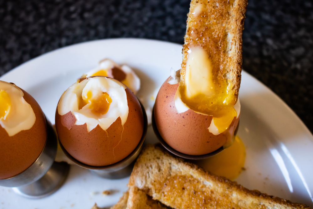 a toast soldier dipped into a runny soft boiled egg