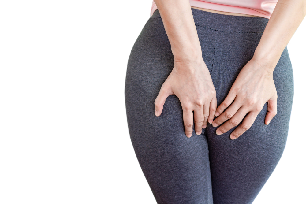 woman hand holding her painful butt caused by hemorrhoids isolated on white background