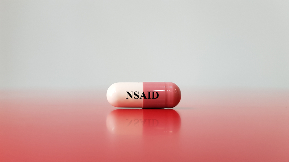 Capsule of NSAID drug on white background(Nonsteroidal anti-inflammatory drug). This medication used for pain control, decrease inflammation, fever treatment, prevent blood clot. Medical concept

