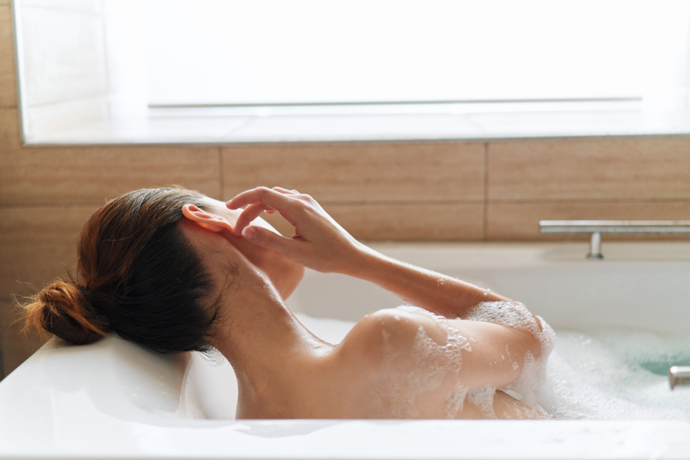 Beautiful woman naked shoulders bathroom spa treatments clean skin