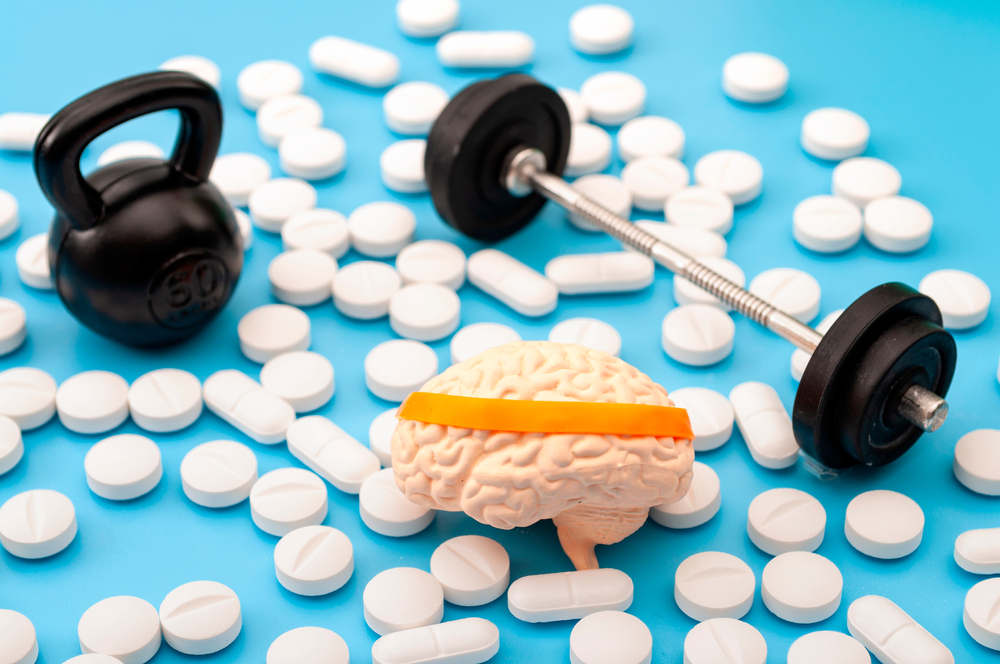 Pharmaceutical supplement for mental fitness, mind health and nootropic drugs concept with human brain with headband, barbell, kettlebell and nootropics