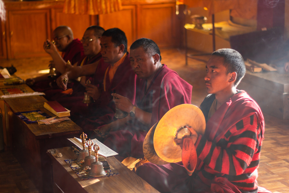 Kaza, Himachal Pradesh, India - May 2012: A novice Buddhist monk with large bronze cymbals in his hands at a traditional ceremony inside the ancient monastery at Kaza in the Spiti Valley.