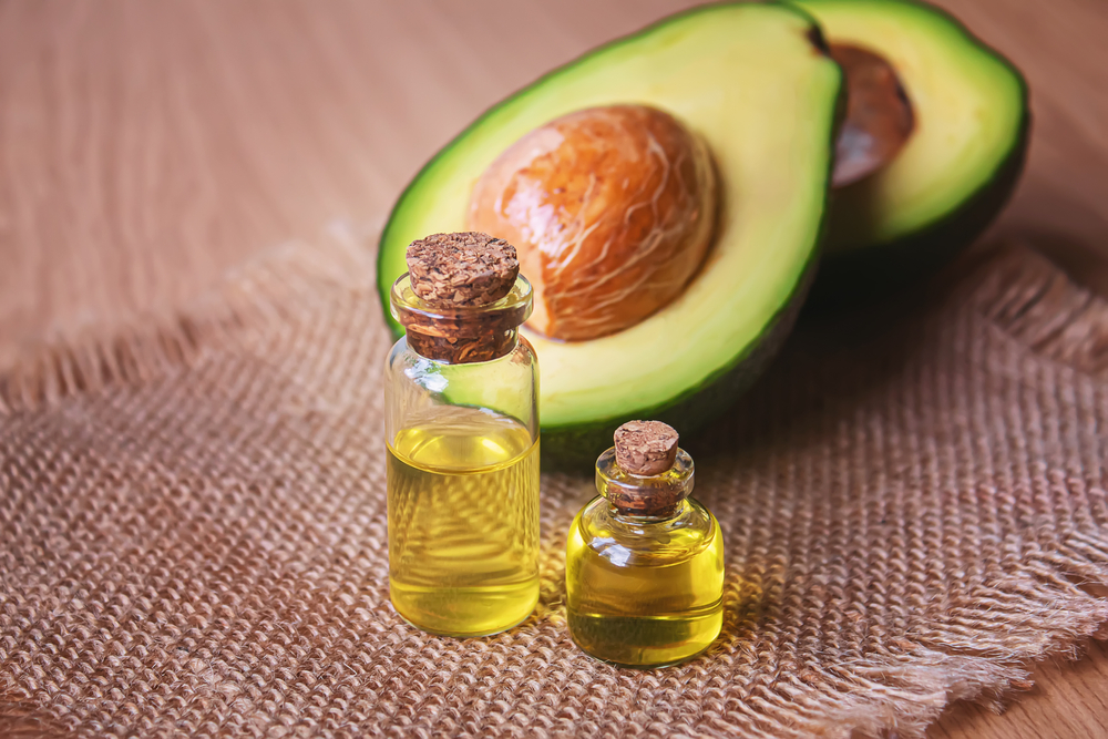 Avocado and avocado oil on wooden background. Selective focus.food