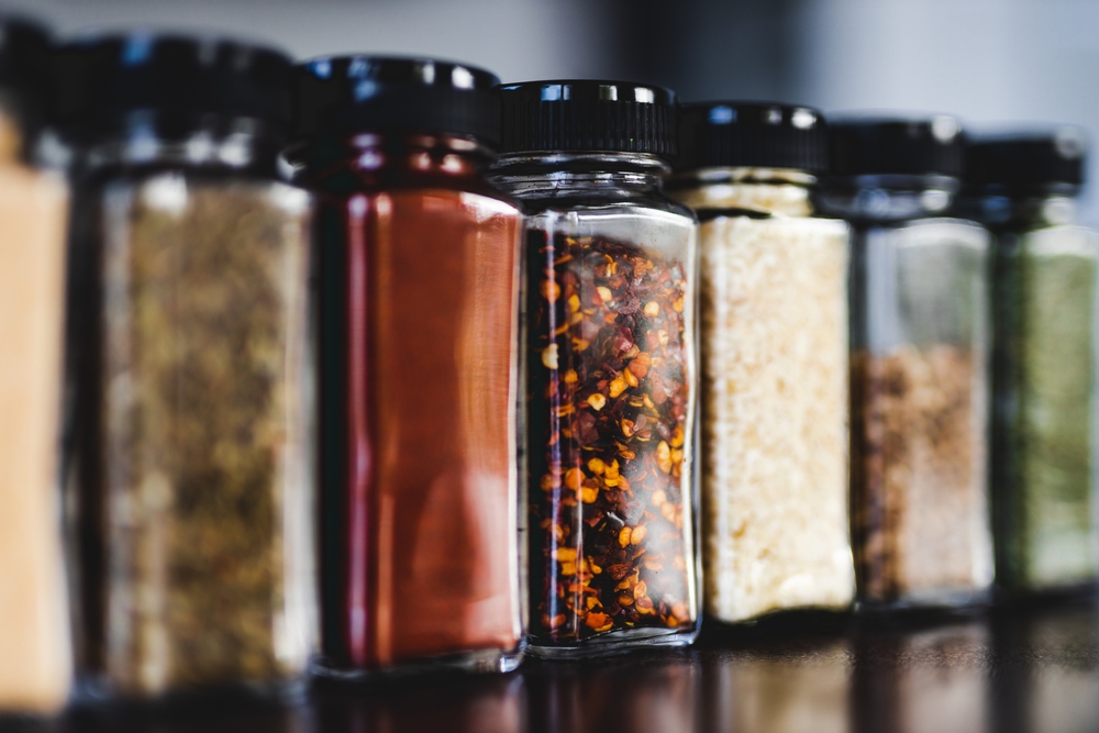 spices seeds and seasonings in matching spice jars on tidy pantry shelf, simple vegan ingredients and concept of flavoring your dishes
