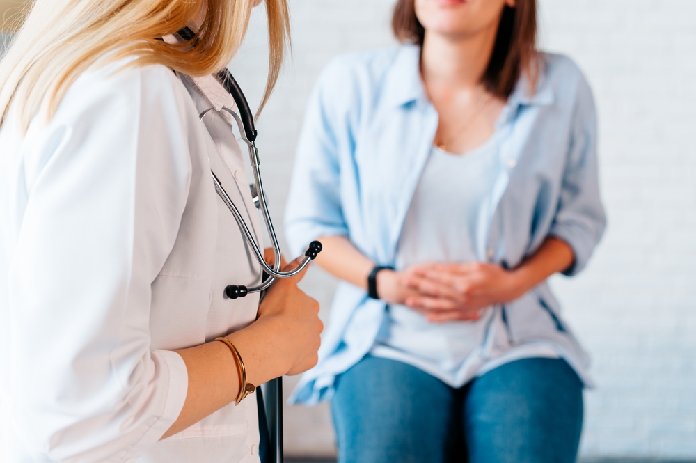 a woman in consultation with a doctor with abdominal pain. It is a painful menstrual period or bladder. And ectopic pregnancy. Immediate treatment immediately.