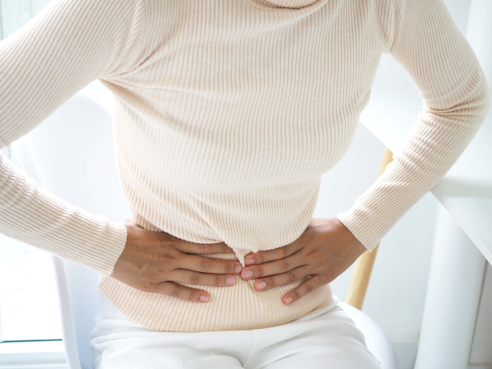 Woman with stomach pain causes of abdominal pain include inflammatory bowel disease-IBD. stomach ulcer irritable bowel syndrome (IBS), ulcerative colitis and microvilli. closeup photo, blurred.