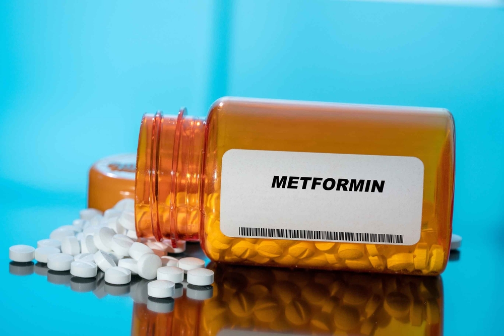 Metformin white medical pills and tablets spilling out of a drug bottle. Macro top down view with copy space.
