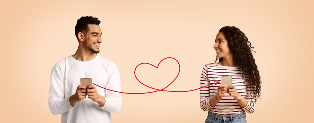 Perfect Match. Smiling Arab Man And Woman Holding Smartphones Connected With Drawn Red Heart Shape String, Romantic Middle Eastern Couple Using Modern Dating App, Creative Collage, Panorama
