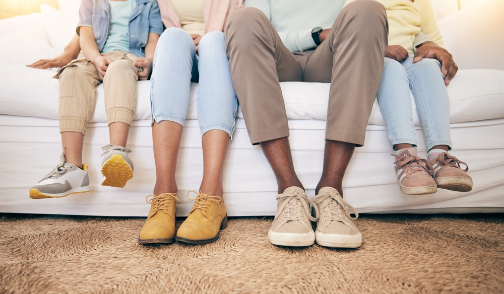 Relax, legs and shoes of black family on sofa for bonding, break and rest together. Support, connection and quality time with parents and children in living room at home for comfort, care and feet
