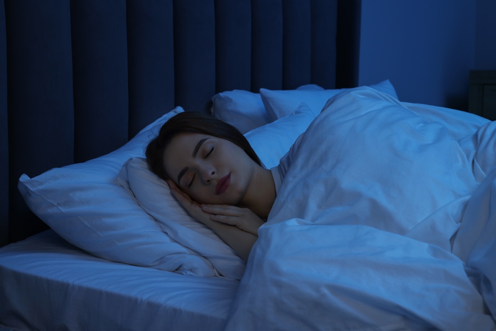 Beautiful young woman sleeping in bed at night
