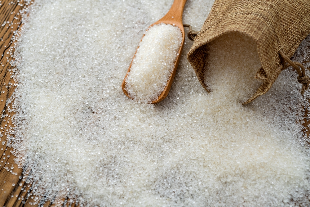 Granulated sugar in sack bag on the table.