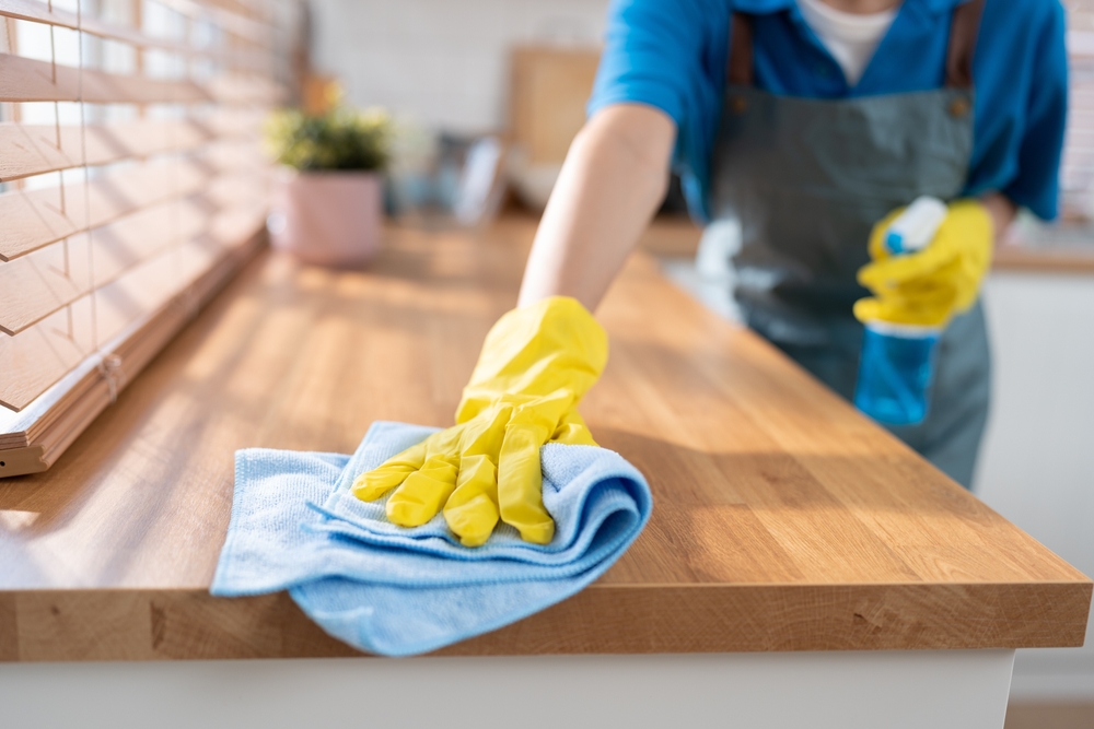 Close up hand cleaning home and wiping with microfiber cloth in kitchen room at home