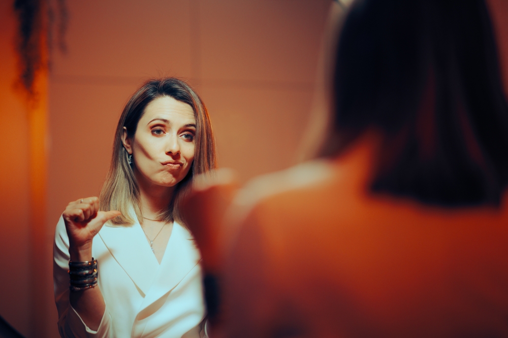 Vain Woman pointing to Herself Looking in the Mirror. Smug Businesswoman thinking in a vain way about herself being narcissistic and overconfident