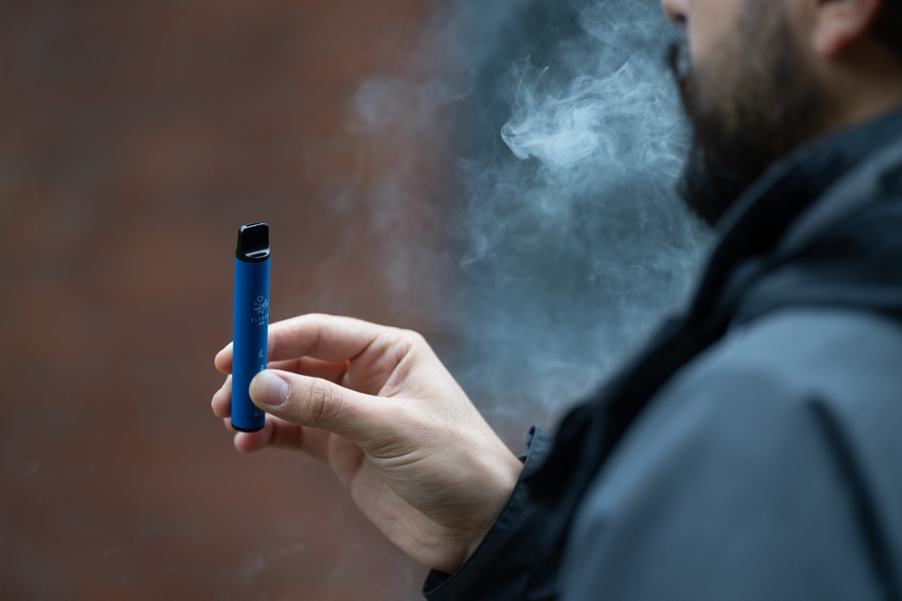 London, UK. 8 August 2023: A man vaping an e-cigarette in London. Local councils are calling for the Government to ban the sale and manufacture of single-use vapes by 2024.
