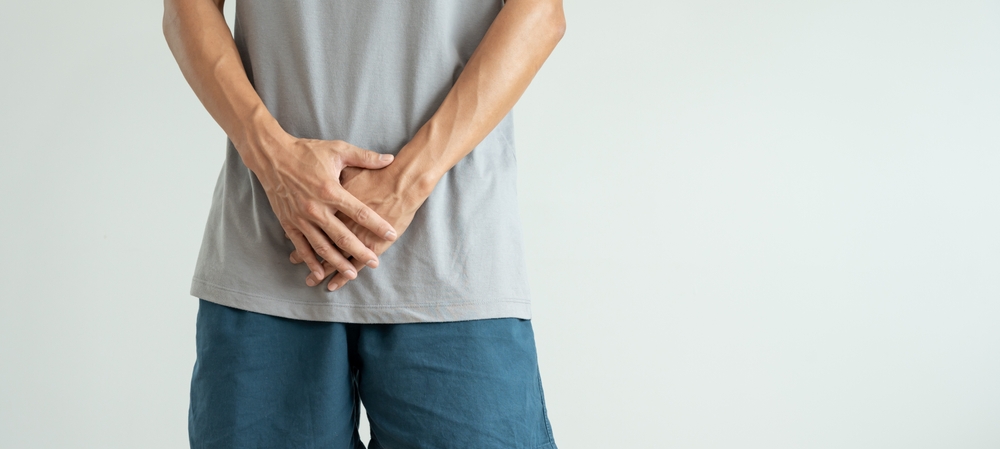Man hold hand in front of private parts feeling discomfort from disease and inflammation. Venereal, testicular cancer. bladder problems, erectile dysfunction, premature ejaculation, prostate cancer