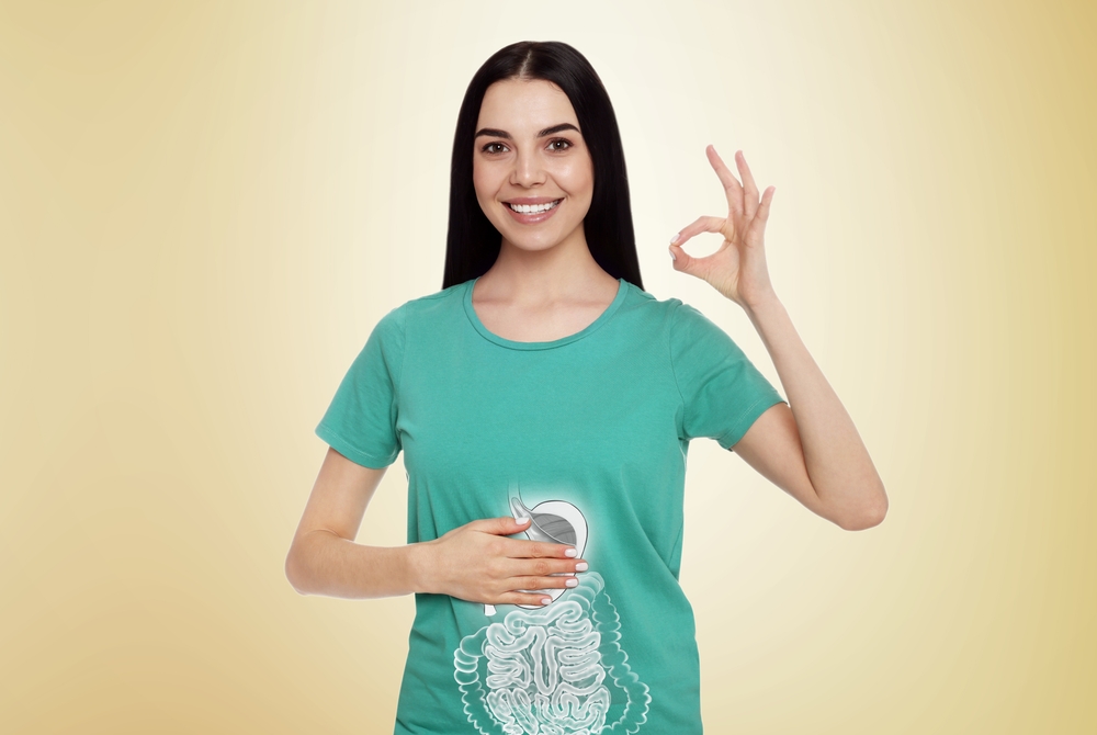 Happy woman with healthy digestive system on light yellow background. Illustration of gastrointestinal tract