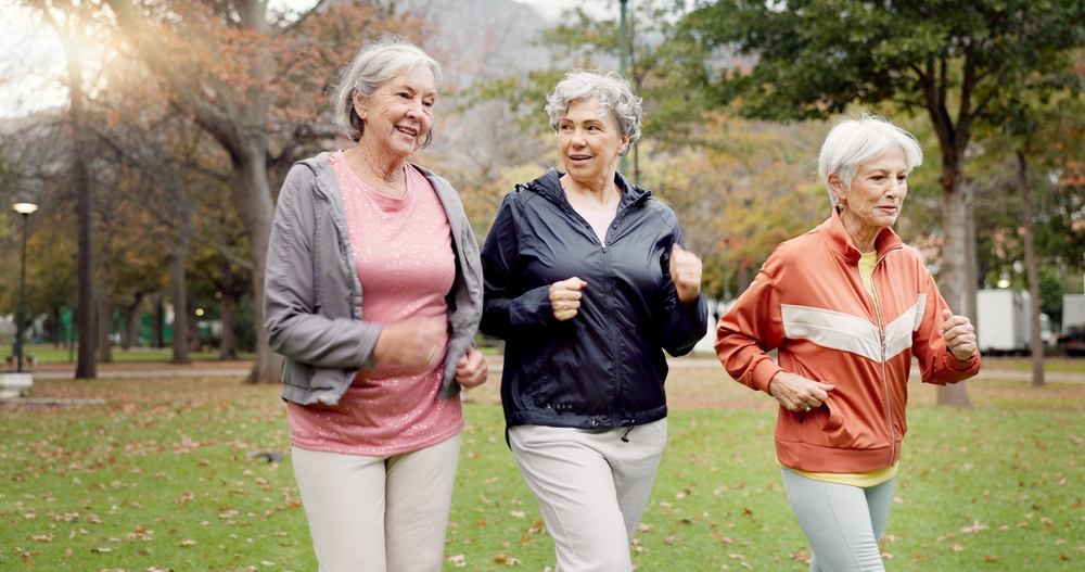 Senior women, walking and friends with fitness, wellness and workout for health in retirement. Park, exercise and elderly female group with motivation and power walk for cardio outdoor together

