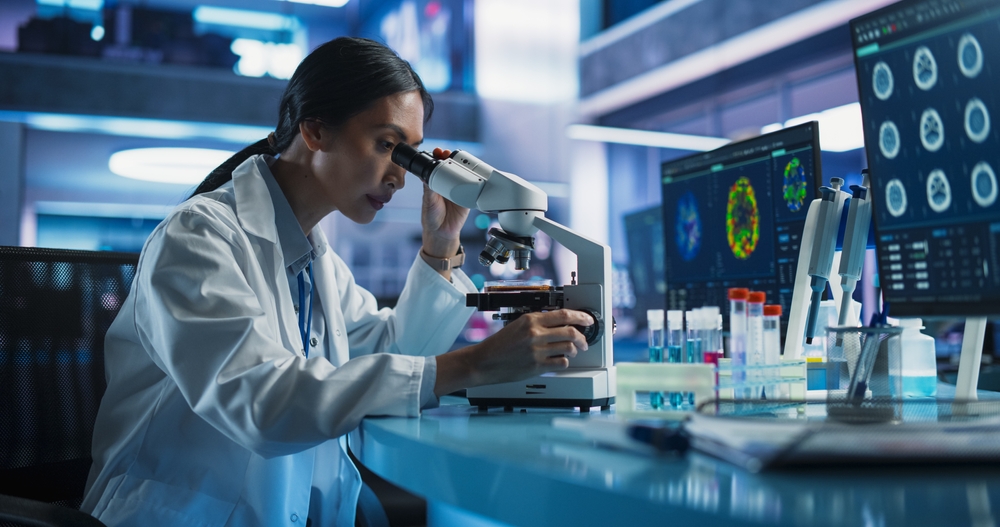 Medical Research And Development Center: Female Asian Scientist Using Microscope To Analyze Petri Dish Sample. Specialist Developing Innovative Medicine For Treating Mental Disorders Or Pain Relief.
