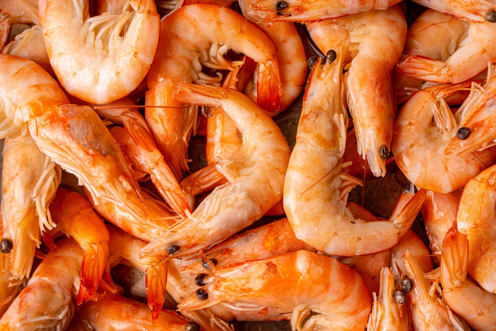 Frozen, boiled shrimp. Texture King prawns background. Seafood on the counter. Fish market. Close-up shot of seafood. Photo of shrimp in a supermarket. Wholesale of seafood. High quality photo