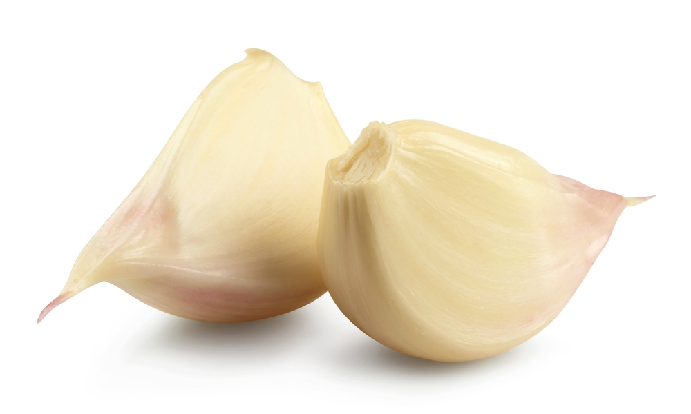 Two cloves of garlic isolated on a white background.
