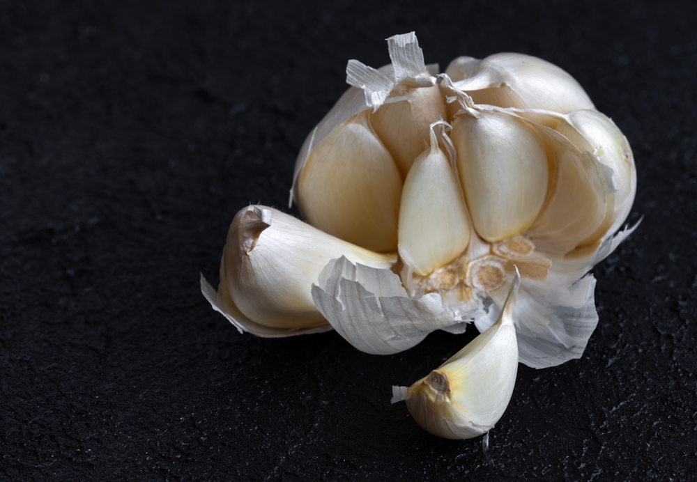 Image of fresh garlic and small garlic cloves inside garlic.
