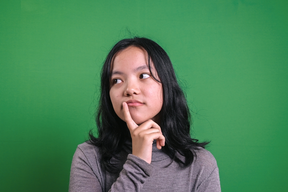 Young Asian Woman With Thinking Gesture, Confuse to Decide.