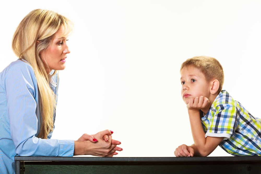 Parenthood domestic life and children upbringing. Mother talking with son little sad boy isolated on white background