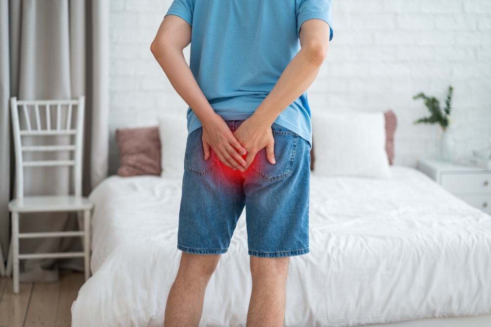 Hemorrhoidal pain, man suffering from hemorrhoids at home, health problems concept