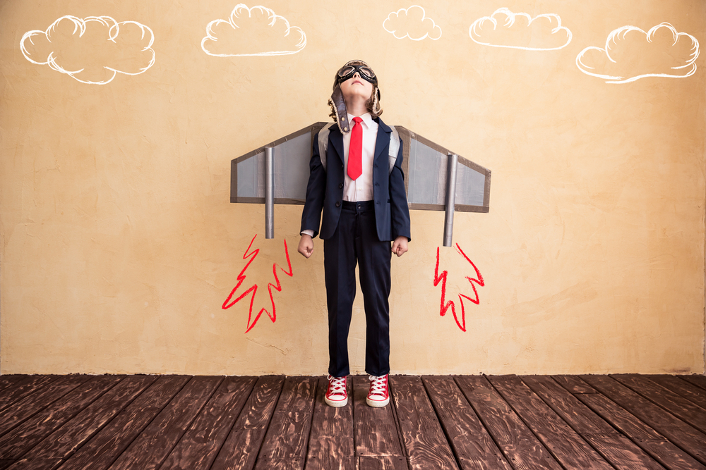 Portrait of young businessman with toy paper wings. Success, creative and start up concept. Copy space for your text